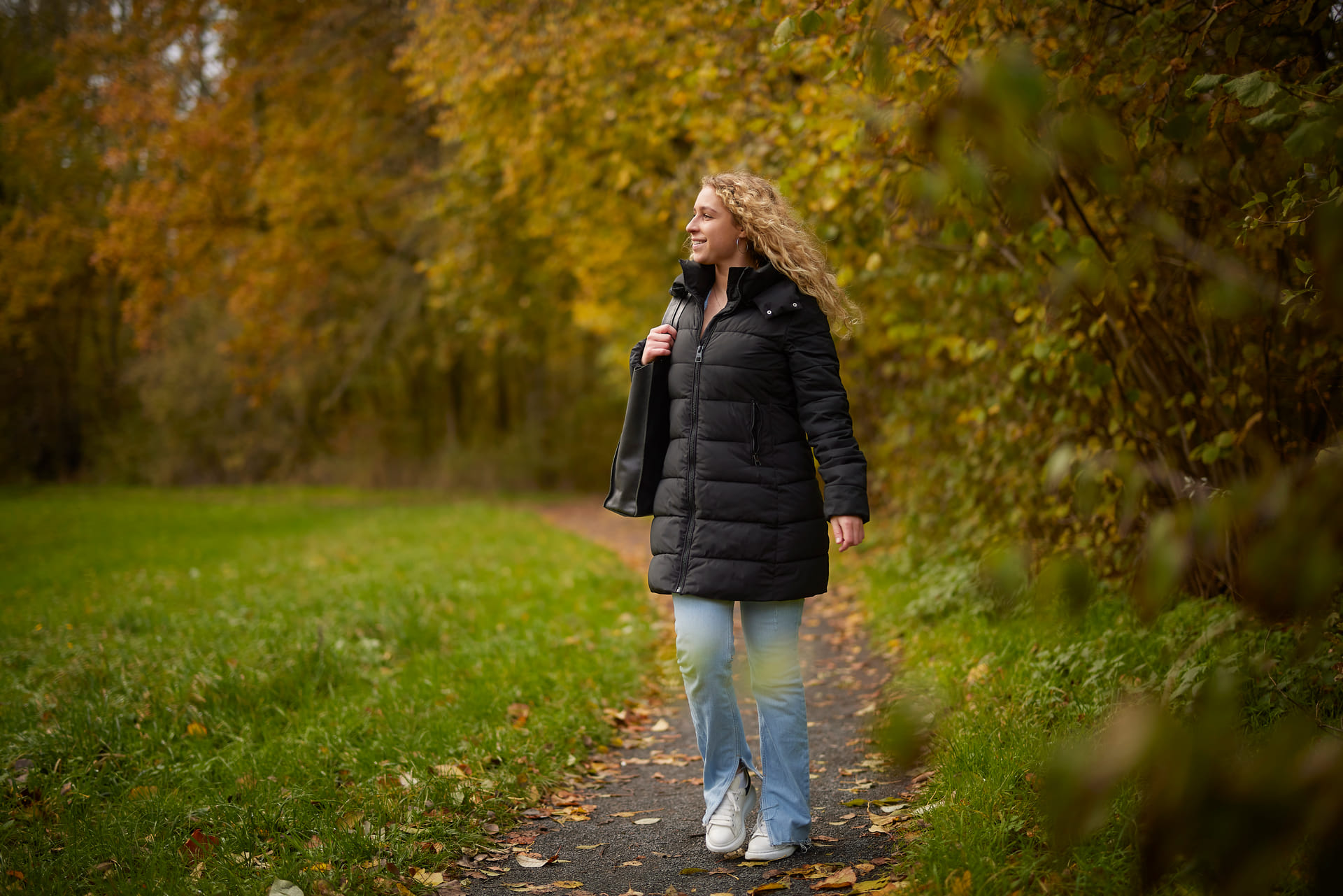 Een mevrouw wandelt door het bos