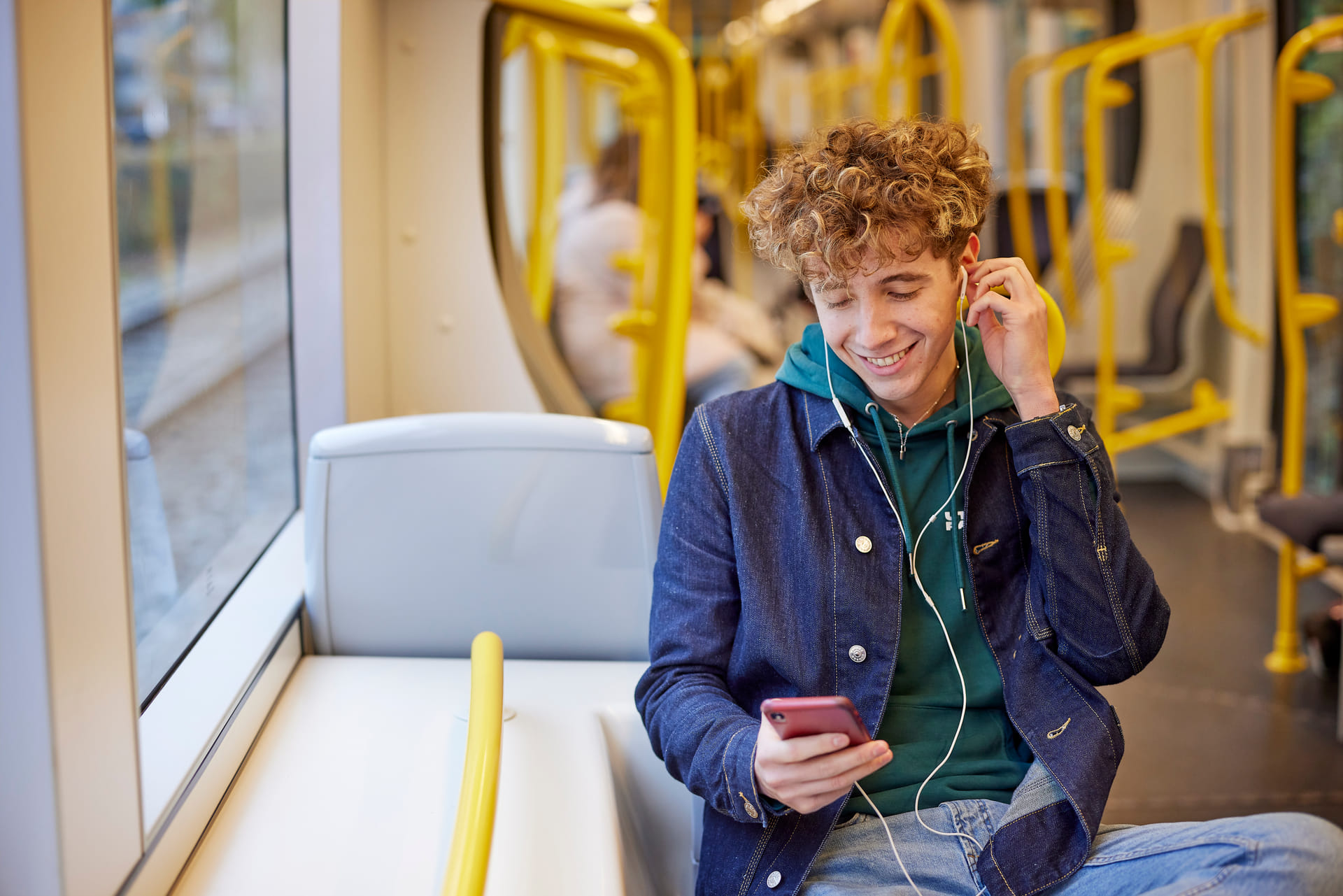 Student die in de tram op zijn smartphone kijkt.
